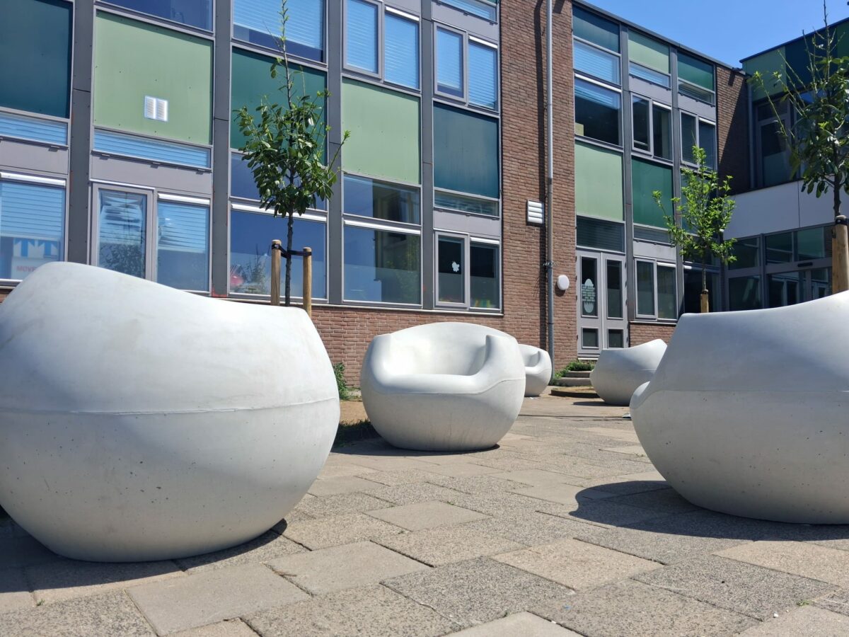 Betonnen zitelementen Stool lijn geplaatst bij school in Gouda 2 Witte betonnen zitelementen uit de Stool lijn geplaatst op een plein in Gouda