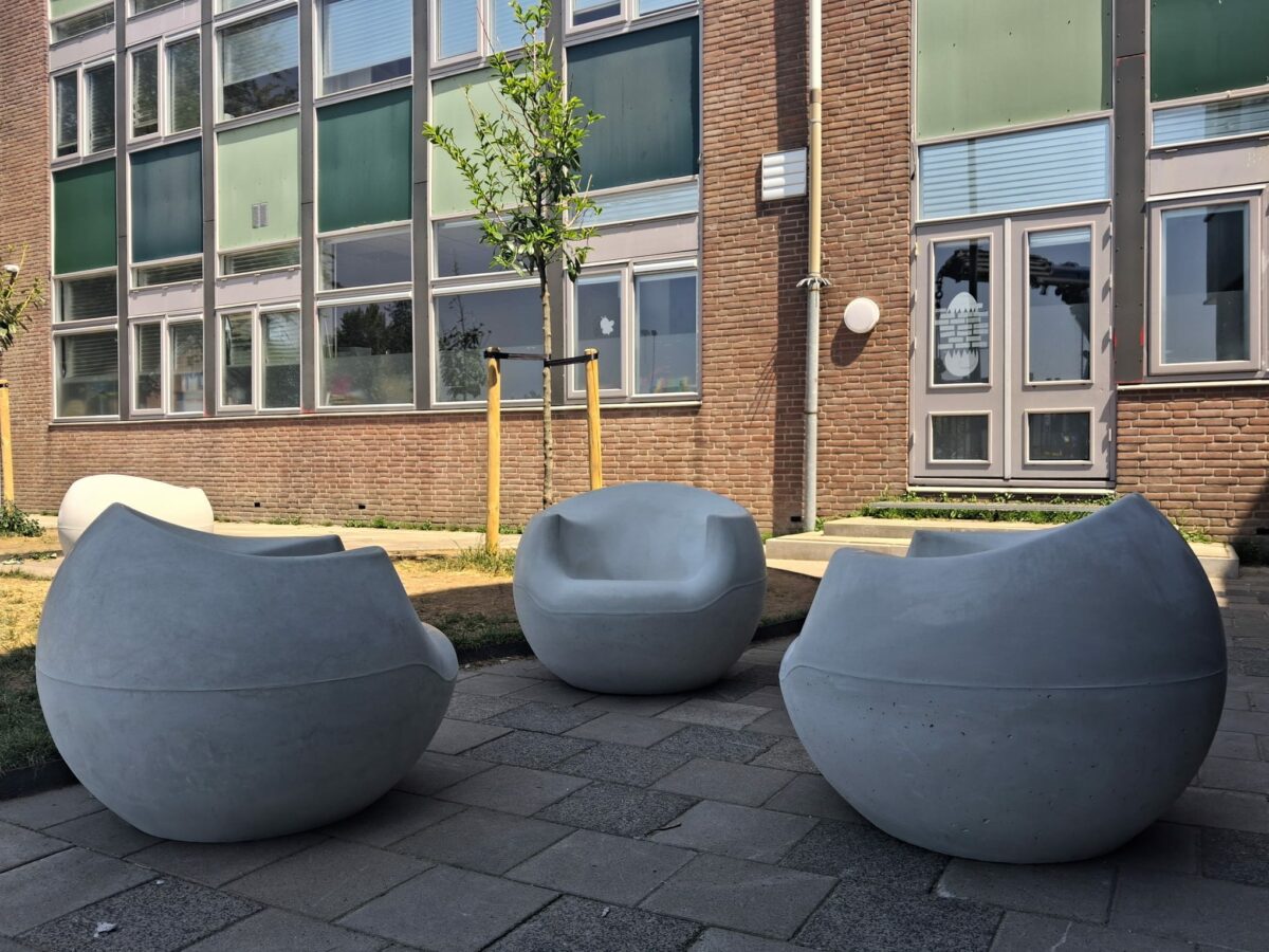 Betonnen zitelementen Stool lijn geplaatst bij school in Gouda 3 Witte betonnen Stool zitelementen op een schoolplein in Gouda