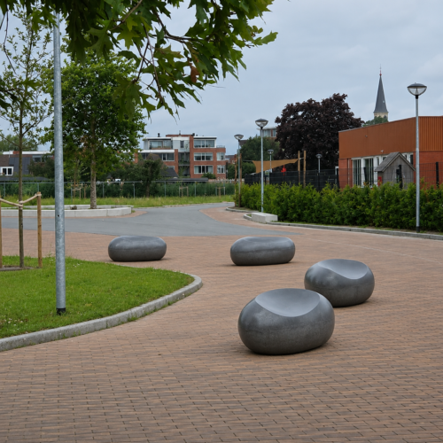 Betonnen zitelement - De Love-stone 20 Meerdere Lovestones zitstenen op een plein in Appingedam, passend in de omgeving met bestrating en groen.