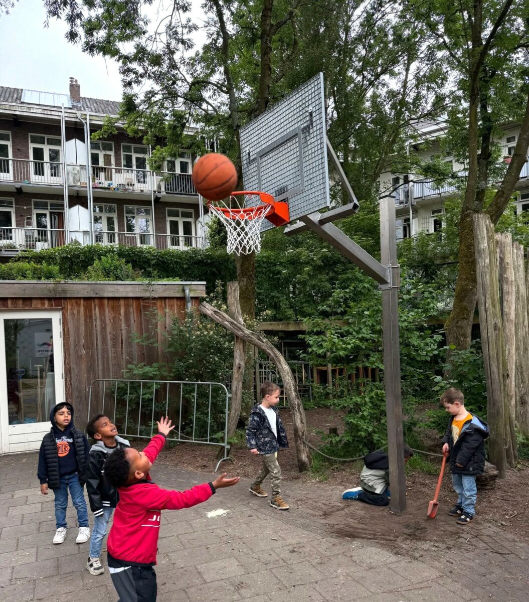 Verstelbare basketbalpaal Rothe+ geplaatst bij AMOS Onderwijs Amsterdam 3 In hoogte verstelbare basketbalpaal in gebruik op schoolplein Amsterdam