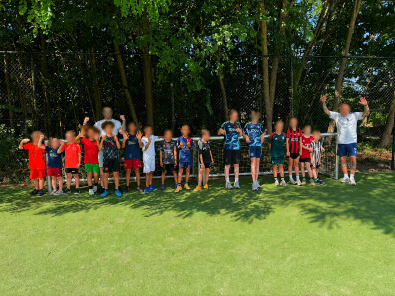 Kinderen en volwassenen poseren enthousiast voor een JVD195 voetbaldoel van 3 x 1 meter bij Landal.