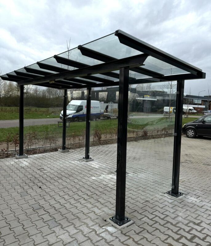 Fietsoverkapping met dak van gelamineerd veiligheidsglas en zwart gecoat frame RAL 9005