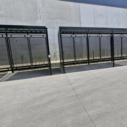 Fietsoverkapping Hagen – Luxe Design & Maatwerk 118 Twee fietsoverkappingen Hagen 6 meter zwart naast elkaar geplaatst op bedrijfsterrein in Veurne België