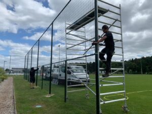 Onze mannen aan het monteren > ballenvanger 5 x 25 m met 3 meter ballenvangnet boven. Geknoopt Pe. Maas 120 x 12 0mm