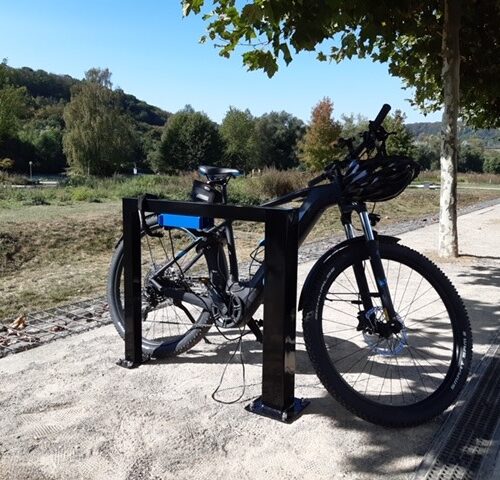 Fietsaanleunbeigel Marion, een ideaal fietsenrek om uw e-bike aan op te laden. Voorzien van geïntegreerde contactdoos met twee oplaadpunten: De aanleunbeugels zijn voorzien van een contactdoos met een verend deksel en voorgeassembleerde bekabeling voor eenvoudige en veilige aansluiting.