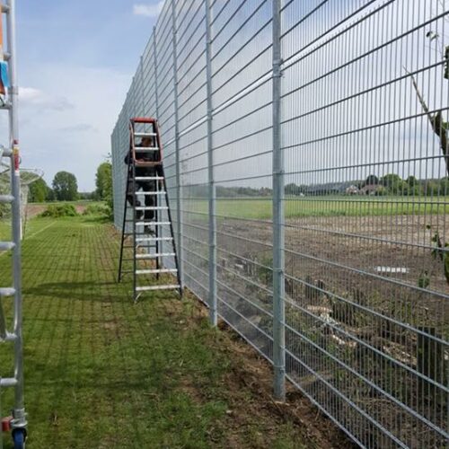 Ballenvanger op maat 110 Monteurs van SKWshop monteren een 5 meter hoge ballenvanger langs een voetbalveld in België