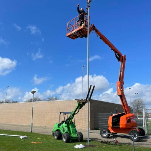 Ballenvanger op maat 154 Monteurs van SKWshop in een hoogwerker tijdens de montage van een ballenvanger langs een voetbalveld