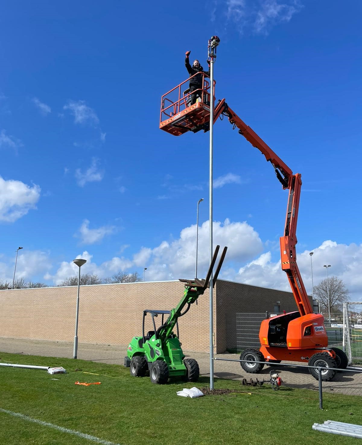 Ballenvanger op maat 73 Monteurs van SKWshop in een hoogwerker tijdens de montage van een ballenvanger langs een voetbalveld