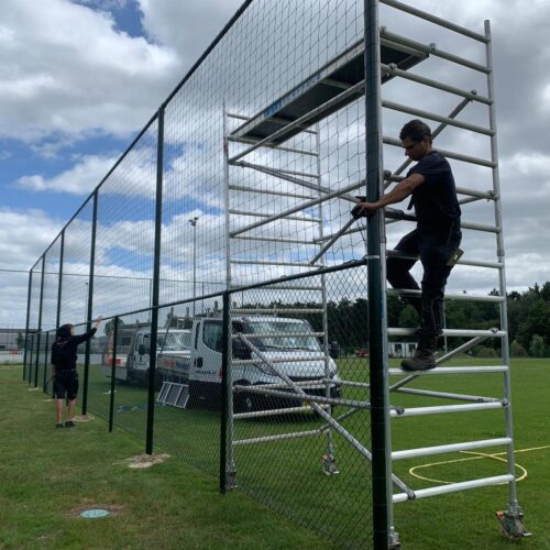 Ballenvanger op maat 141 Monteurs van SKWshop op een steiger tijdens de montage van een ballenvanger langs een voetbalveld