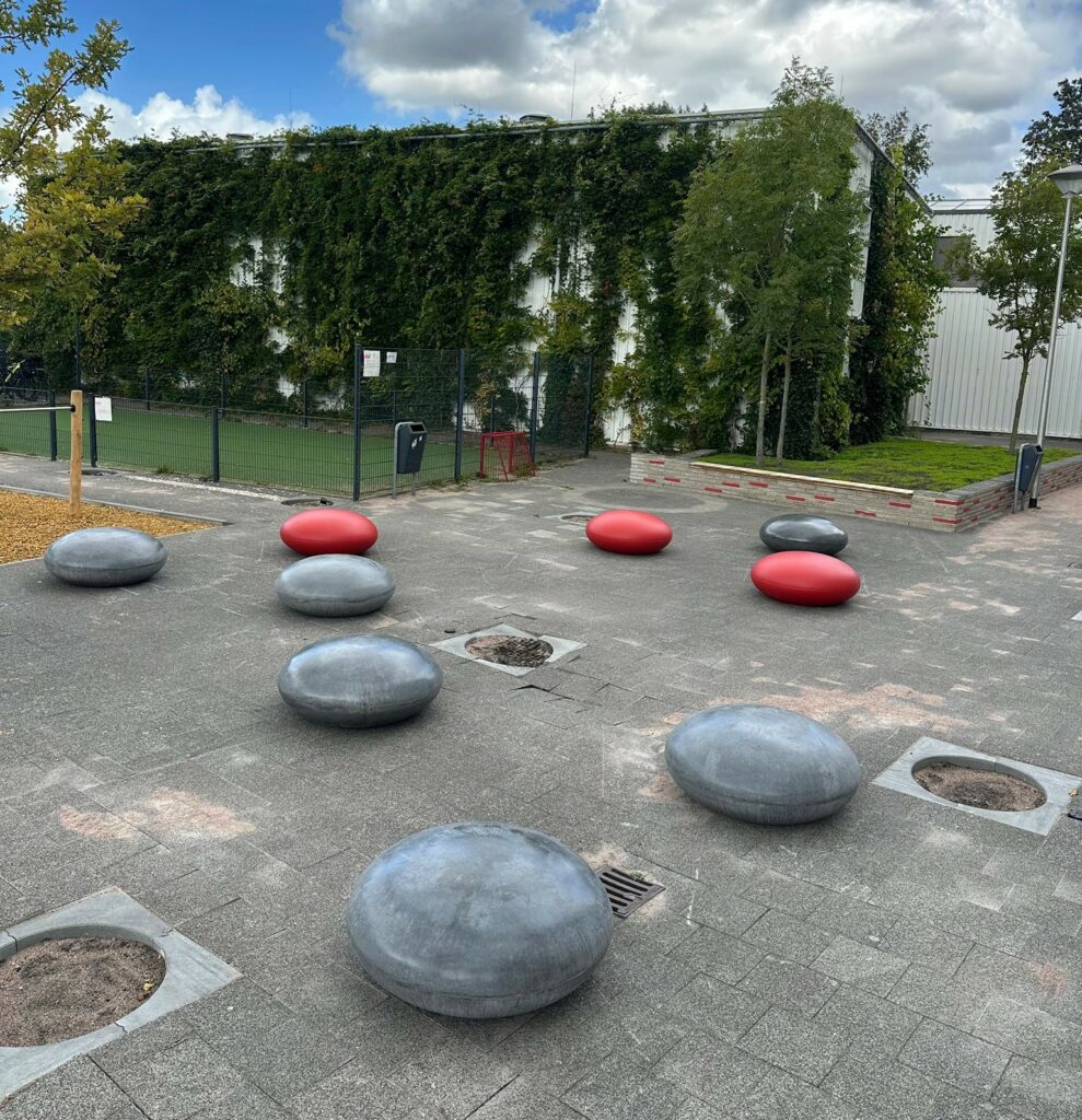 Betonnen zitelementen Stool lijn geplaatst bij school in Gouda 6 Betonnen reuze smarties gecoat in het rood en antraciet