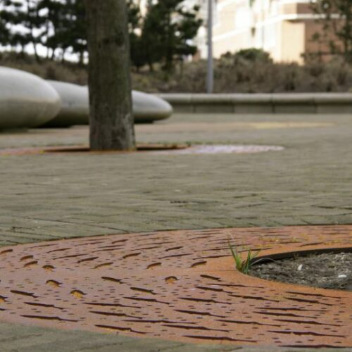 Boomrooster Corten 16 Boomrooster Corten, ronde variant. Samen afgebeeld met de betonnen Smarties