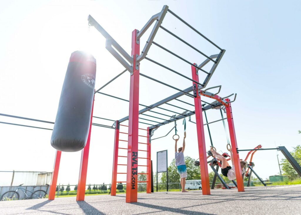 Inclusief beweegpark inrichten: buitenfitness en kinderfitness combineren 6 Nippur L+ calisthenics toestel met pull-up bars, monkey bars, dips en danspaal voor buitenfitness en calisthenics
