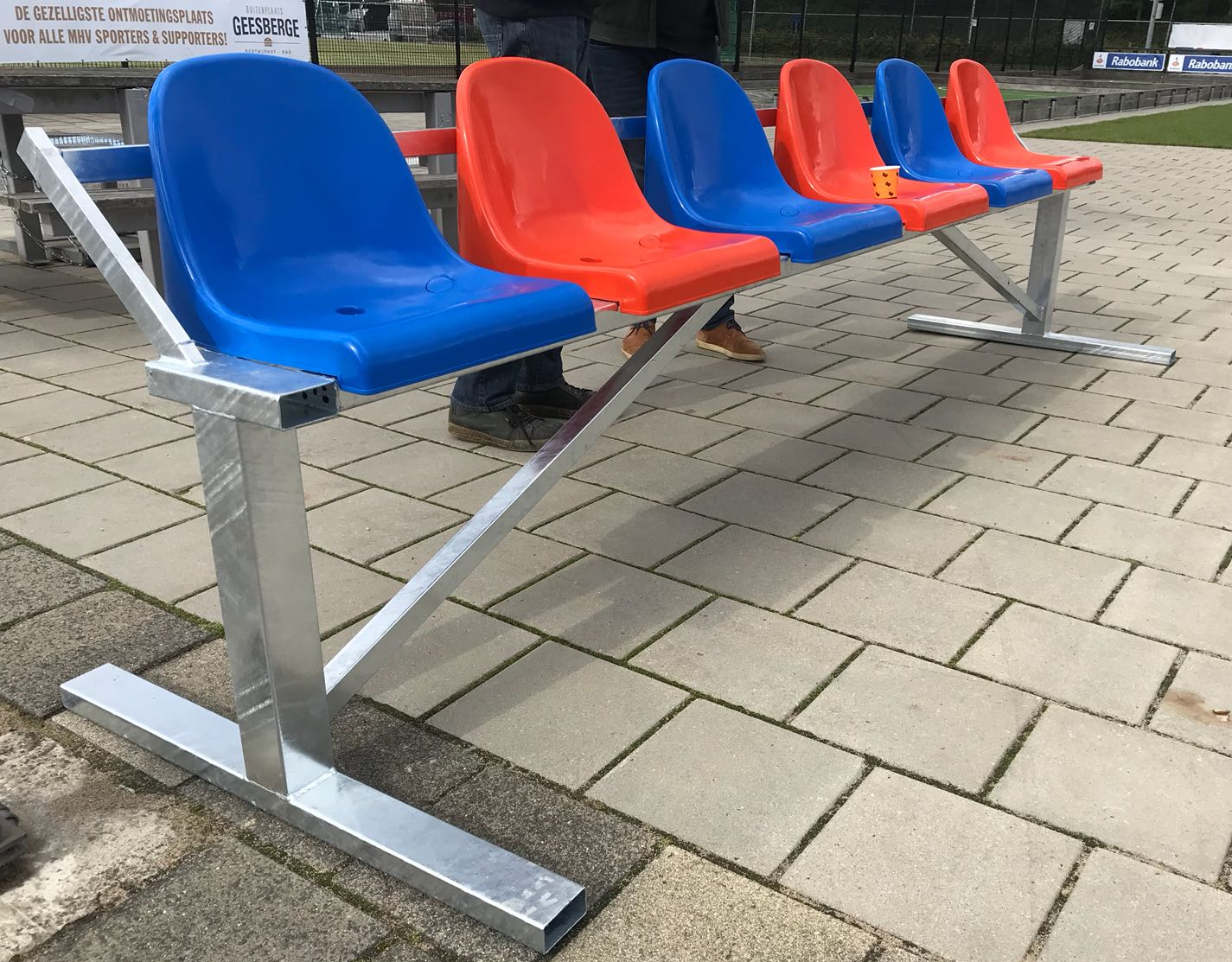 Tribune- dugout zitjes 8 Onze reservebank - coachbank met de kunststof kuipzitjes en blauw en rood. Een uitetsekend zitcomfort.