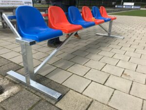 Reservebank, 2,5 m, met blauw, oranje zitjes.