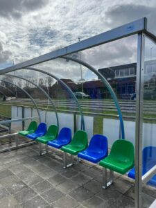 De bij vv TLC (Leek) geleverde dug-outs, lengte 4 meter met groene=en blauwe zitjes (de clubkleuren)