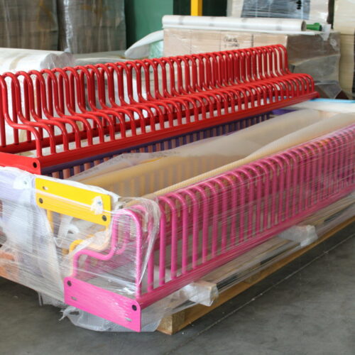 Fietsenrek model Gamma 37 Gereed voor transport, de betonsteunen liggen op een aparte pallet. De fietsenrekken uitgevoerd in de kleuren van de regenboog.