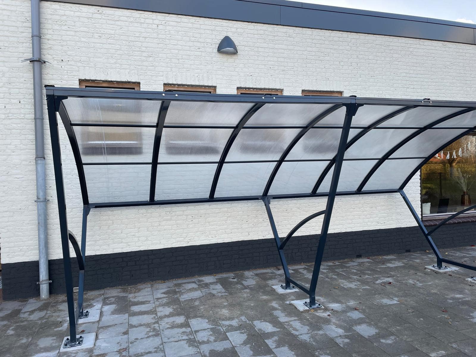 Fietsoverkapping Velo - Compact en Voordelig 3 Overdekte fietsenstalling - fietsoverkapping Velo 5m. Ideaal voor a 12 fietsen. Met zijn stijlvolle ontwerp past de fietsoverkapping Velo daarnaast perfect in elke buitenruimte.