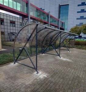 Fietsoverkapping bij een modern gebouw.