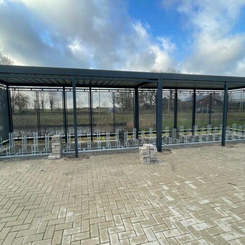 Fietsoverkapping Hagen – Luxe Design & Maatwerk 88 Dankzij de modulaire opbouw van de fietsoverkapping Hagen kunt u eenvoudig een maatwerk fietsenstalling creëren die past bij de beschikbare ruimte en uw specifieke wensen. OP de afbeelding de montage van een 12 meter uitvoering van deze fraaie fietsenstalling