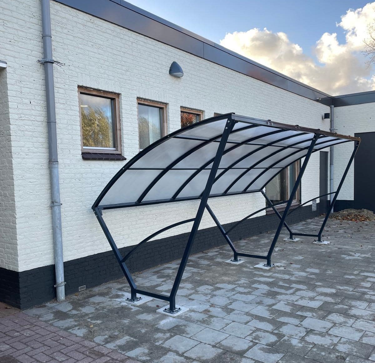 Fietsoverkapping Velo - Compact en Voordelig 11 Stavenisse, zwart gecoat. Minimalisme op zijn mooist. De Velo fietsenstalling is niet alleen functioneel, maar ook een esthetische meerwaarde voor uw buitenomgeving.