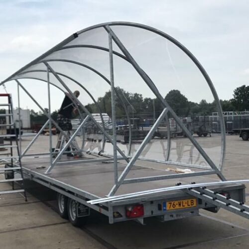 Rookoverkapping - rookabri BF1000 98 Op de afbeelding wordt de BF1000, hier als rijwieloverkapping afgemonteerd op de aanhanger. Zodat we deze verkapping met een lengte van 6 meter volledig gemonteerd naar de afleverlocatie kunnen brengen