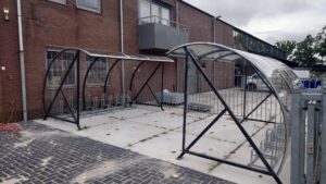 Fietsoverkappingen naast een gebouw. Met fietsenrekken.
