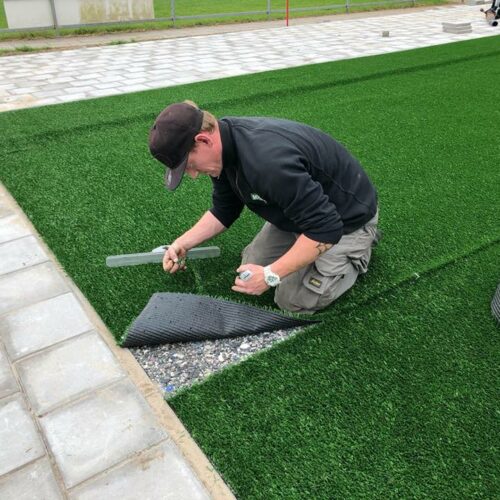 Kunstgras speelvloeren 80 Hier bezig met het leggen van onze LSR 24 mm kunstgrasmat op een sporttechnische foamlaag. In Dordrecht,
