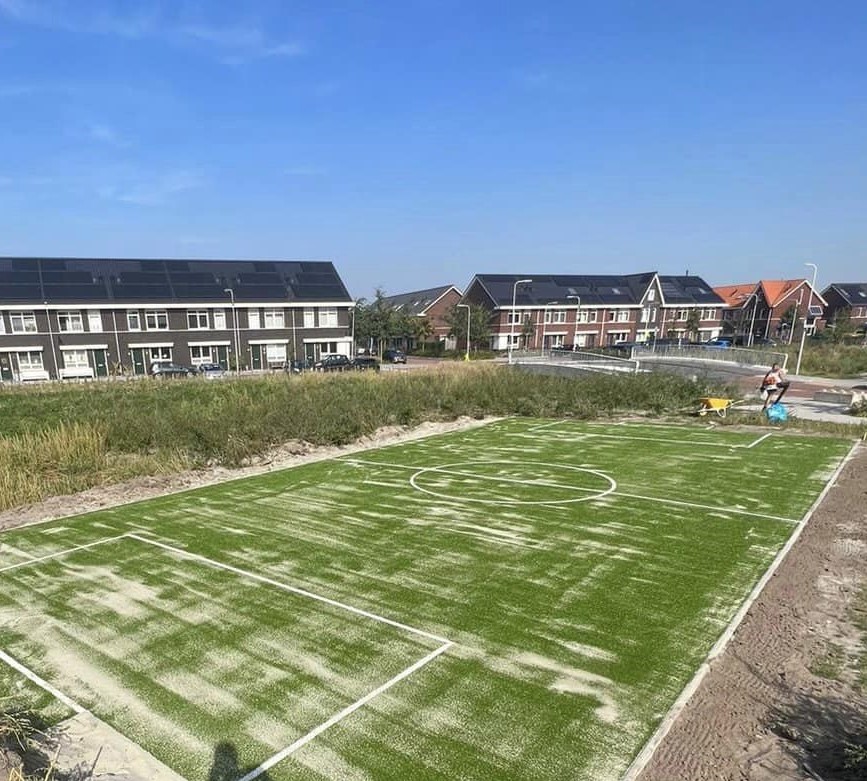 Kunstgras speelvloeren 48 Zandgevuld kunstragsveld in s-Gravenzande pool 24mm met ingelegde belijningen. Aansluitend plaatsen we de pannakooi. 7.5 x 15m uit onze populaire Premiumserie.
