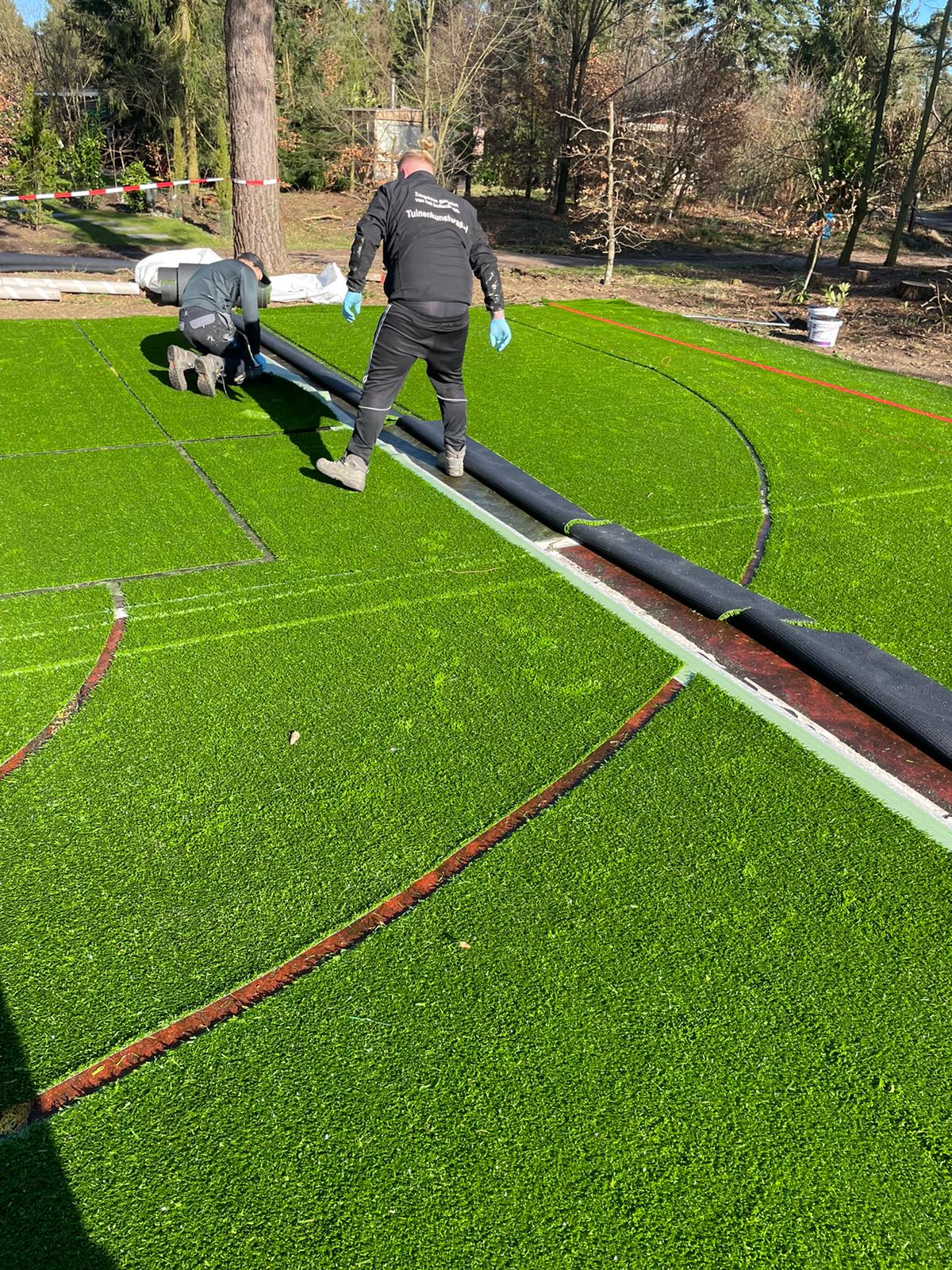 Kunstgras speelvloeren 44 Aanleg grote sportkooi bij de Paalberg, het insnijden van de belijningen en het leggen van de kunstgras speelvloer