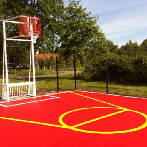 Sportvloercoating 56 Onze pannakooi -basketbal -combinatie. Rood gecoate vloer, voorzien van witte en gele belijningen.