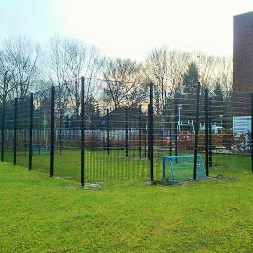 Pannakooi PS100 Basic 106 Pannakooi PS100 geplaatst op gras met een net-overdekking, zodat de bal altijd in het spel blijft. Afmetingen, 7.5 x 15 meter, wanden van de pannakooi 3 meter hoog.