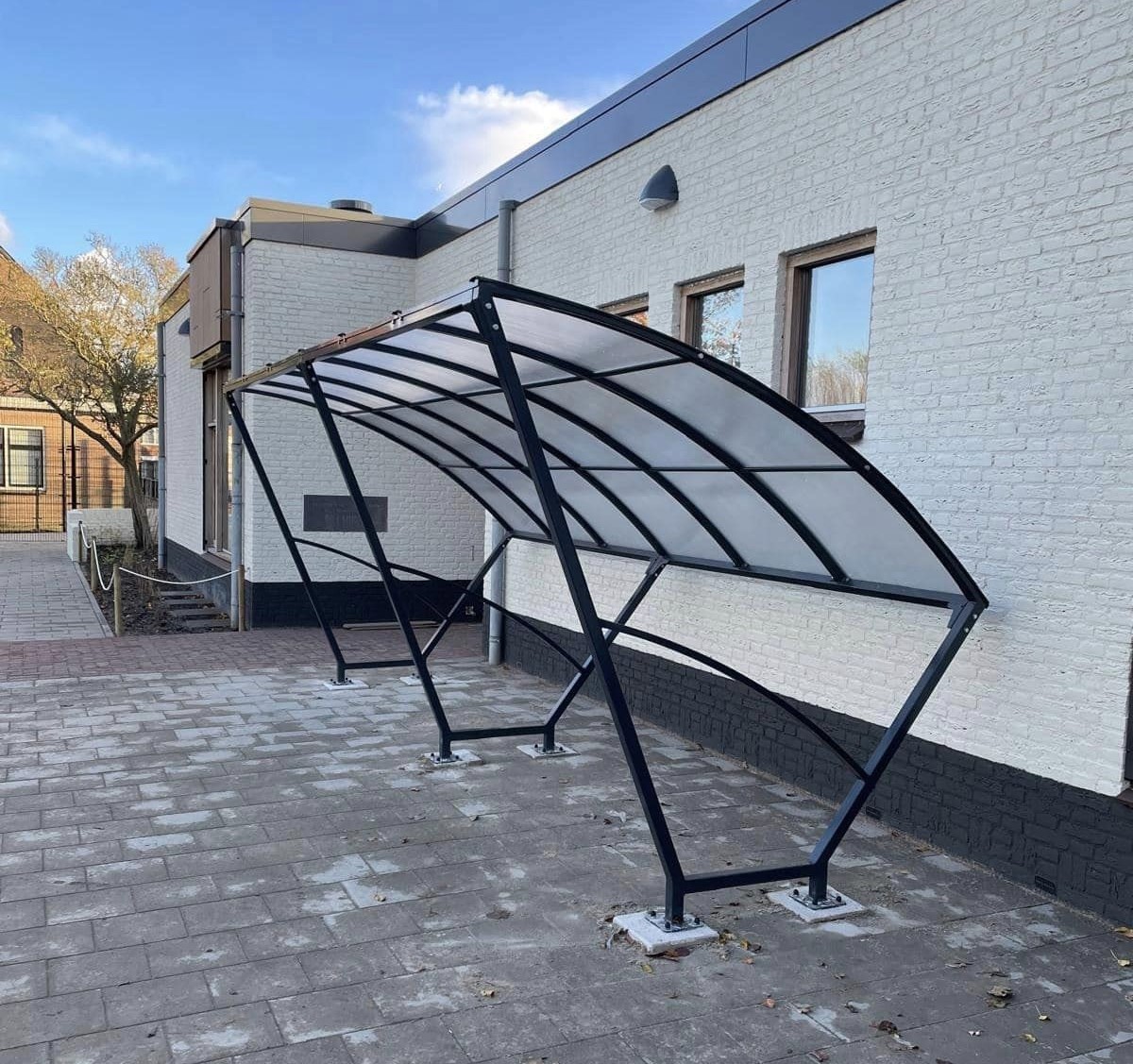 Fietsoverkapping Velo - Compact en Voordelig 12 De elegante gebogen dakconstructie van de Velo fietsoverkapping maakt het een visueel aantrekkelijke toevoeging aan iedere ruimte en geeft uw bezoekers, medewerkers een nette plek om hun fiets te stallen.