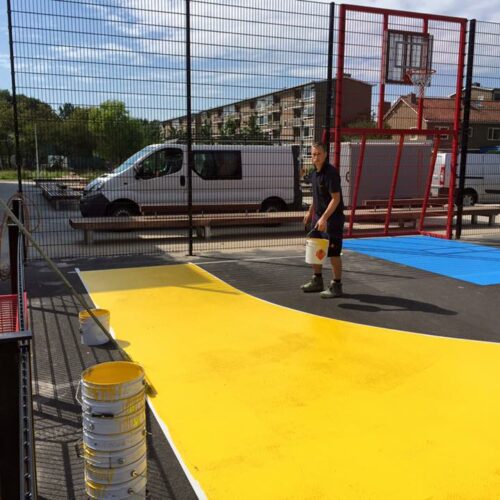 Sportvloercoating 45 Werkzaamheden grote voetbalkooi, sportkooi in Rotsoord Utrecht. Op de afbeelding ziet u het aanbrengen van de Granuplast rolcoating. .