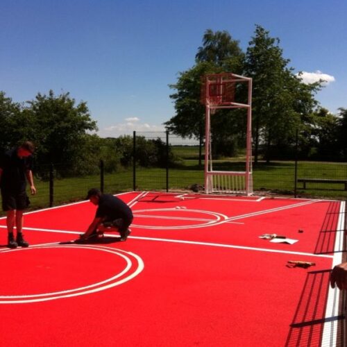 Sportvloercoating 40 Pannakooi met basketbal. Coating van sport en spelvloeren. De mogelijkheden zijn legio. Afgebeeld de werkzaamheden bij de door ons geplaatste mini multi-sportkooi in de gemeente Slochteren.