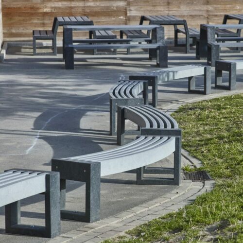 KUnststof Picknicktafel Matrix 34 Op de voorgrond onze gebogen parkbanken model Canvas en op de achtergrond picknicksets model Matrix. Alle in de grijze uitvoering.