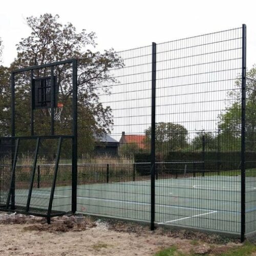 Waterdoorlatend beton 19 Een voetbalkooi met basketbal uit onze Premium-serie voorzien van een drainbeton speelvloer met groene coating en belijning.
