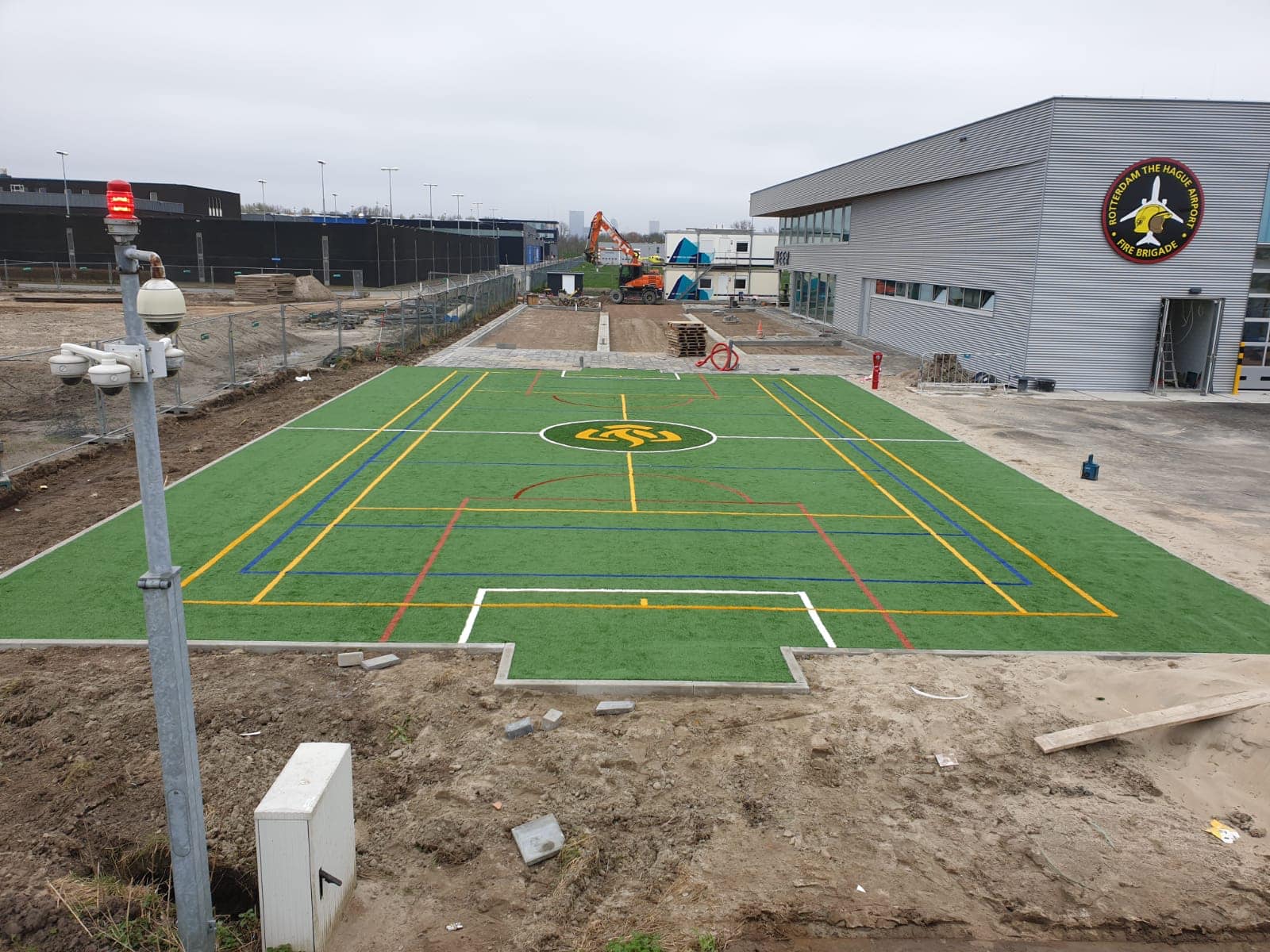 Kunstgras speelvloeren 31 De kunstgras speelvloer van de voetbalkooi is gereed. Met logo, voetbal-, tennis en volleybal-belijningen.