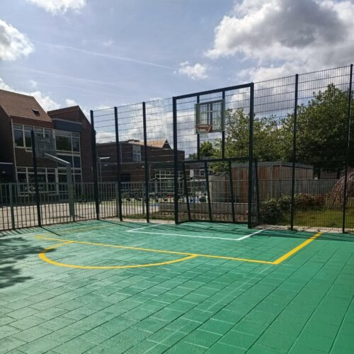 Sportvloercoating 73 Sportkooi Heerlen met een groene Granuplast rolcoating en gele en witte sportbelijningen.