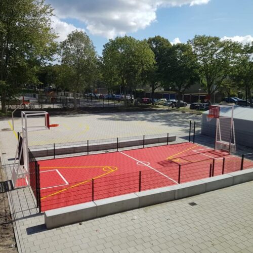 Pannakooi met basketbal 110 Pannakooi met rode speelvloer en basketbaldoelen in Amsterdam op schoolplein.