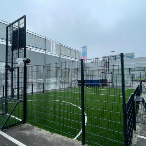 Pannakooi met basketbal 156 Geluidsarme pannakooi met kunstgras in Hoogvliet. Met 4 kleine doelen in de lange zijden en 2 grote doelen met basketbal in de korte zijden.