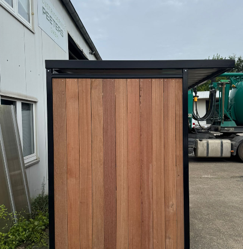 Fietsoverkapping Nordic – Met FSC-Hardhout 18 Zijaanzicht van fietsoverkapping Nordic met FSC-hardhouten wandbekleding en zwart gepoedercoat stalen frame, geplaatst bij Group Peeters in Nörvenich (Duitsland).