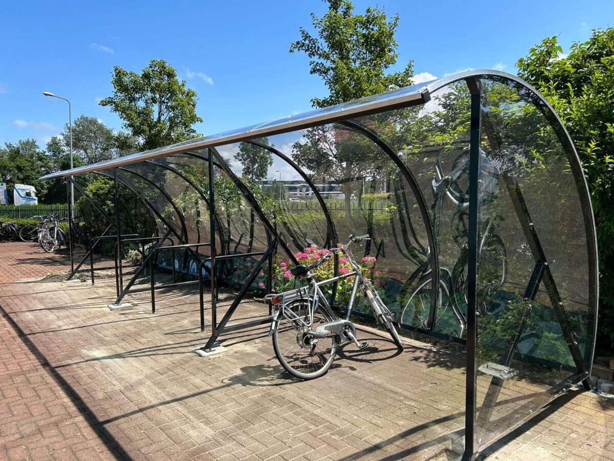 Hoe beveilig je een fietsenstalling tegen diefstal? 2 fietsoverkapping transparant lengte 9 meter met fietsnietjes op bedrijfsterrein