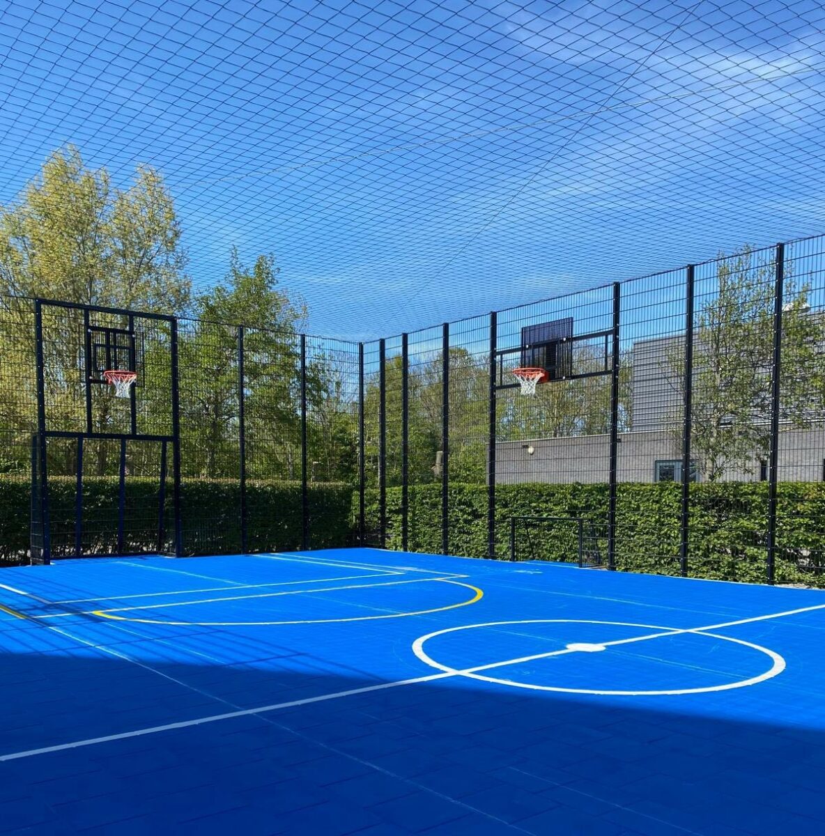 Pannakooi kopen? 1 Overdekte sportkooi met netoverdekking, blauwe Granuplast sportvloer, sportbelijning en voetbaldoel-basketbalcombinaties.