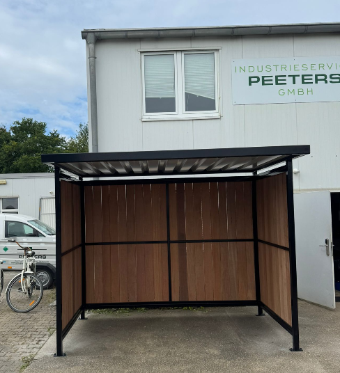 Fietsoverkapping Nordic geplaatst bij Group Peeters in Nörvenich (Duitsland) 4 Vooraanzicht van fietsoverkapping Nordic met FSC-hardhouten wanden en frame in RAL 9005 bij Group Peeters Duitsland, Nörvenich