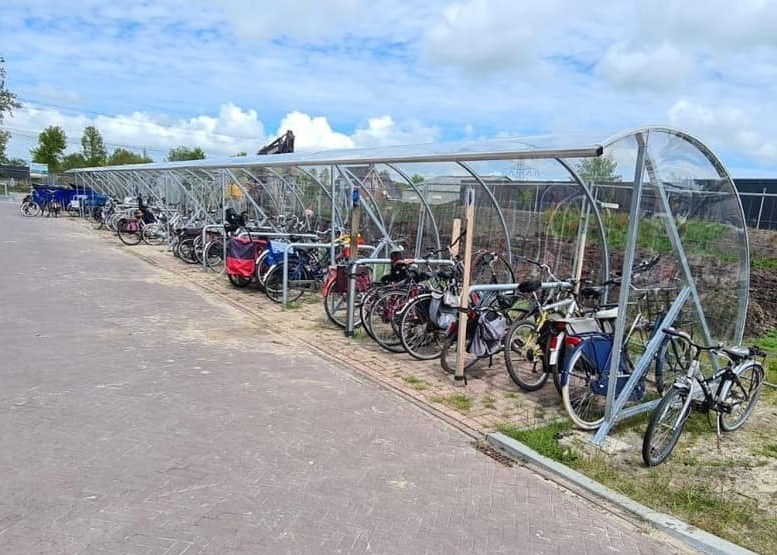 Een fietsoverkapping plaatsen? 17 onmisbare vragen vooraf 1 Lange BF1000 fietsoverkapping in verzinkte uitvoering met geparkeerde fietsen in de openbare ruimte