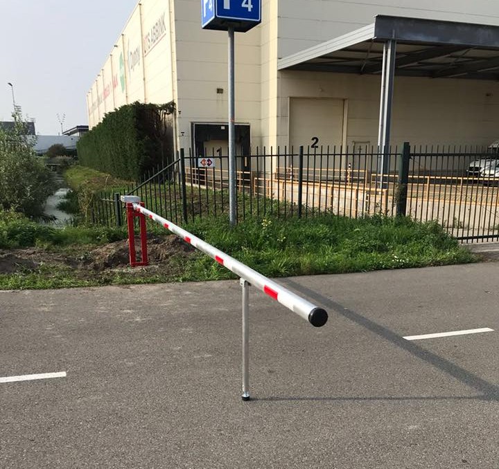 Wat kost een slagboom? Alles over prijzen, uitvoeringen en mogelijkheden 4 Handbediende slagboom van 6 meter met pendelsteun gemonteerd op bedrijfsterrein voor toegangscontrole van voertuigen