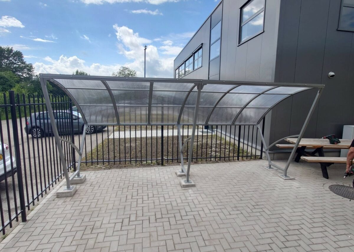 Fietsoverkappingen geplaatst in Varsseveld en Tienen 2 Fietsoverkapping model Velo van 5 meter met gecoat frame en polycarbonaat dak op bedrijfsterrein in Varsseveld.