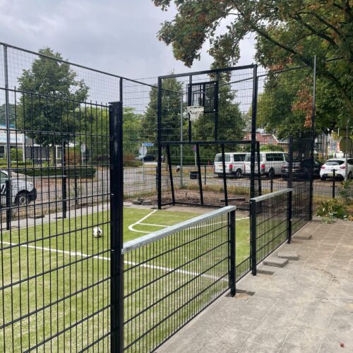 Pannakooi met basketbal 164 Maatwerk sportkooi met zwarte wanden, combidoelen en basketbalvoorzieningen