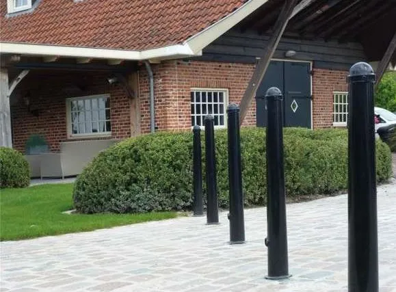 Welke parkeerpaal of afzetpaal kiest u? Verschillen, toepassingen en plaatsing 5 Conische parkeerpalen aan de weg bij een boerderij