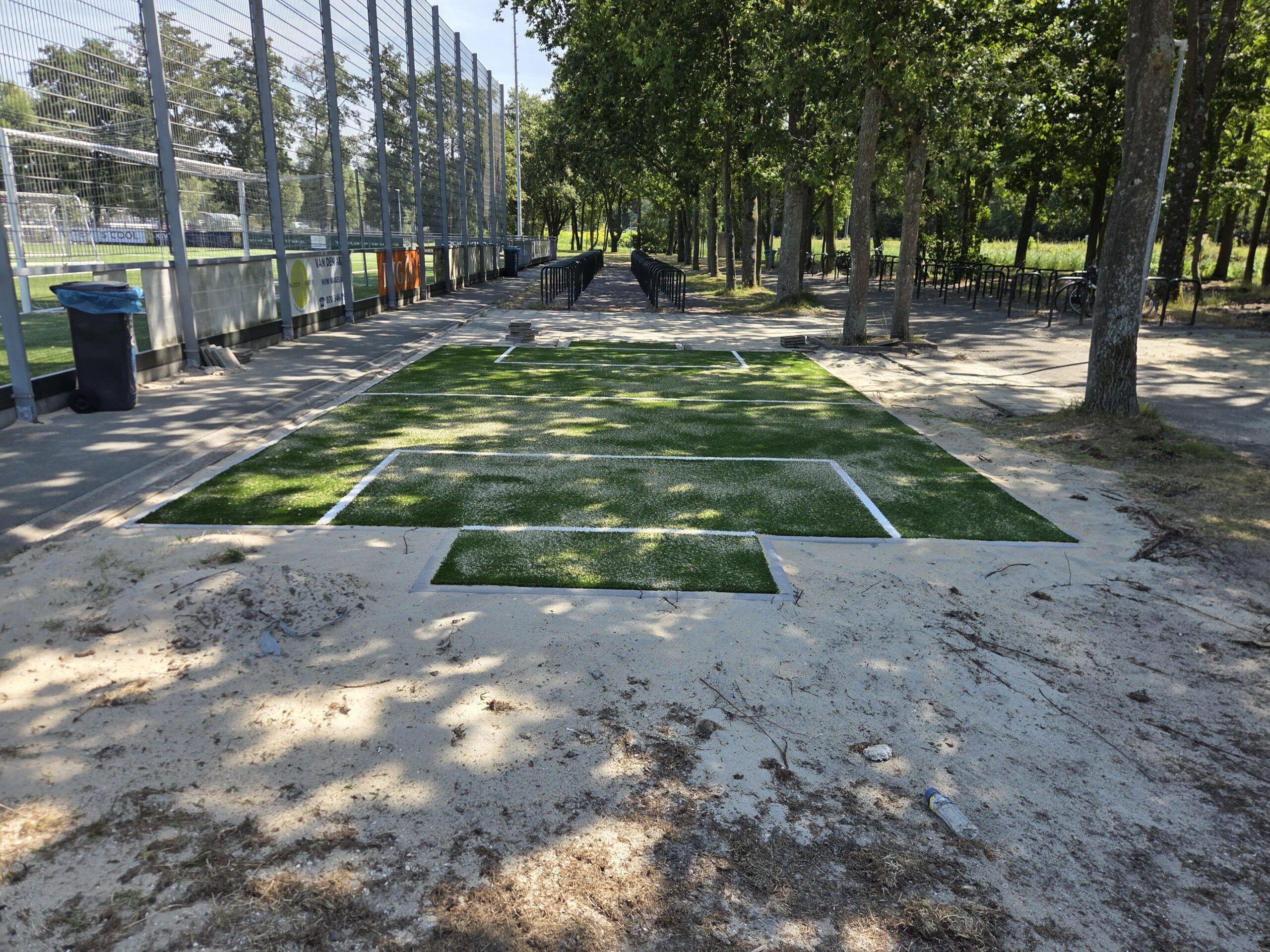 Kunstgras speelvloeren 39 Kunstgrasveld met nieuwe belijning gereed voor de montage van een pannakooi in Wassenaar.